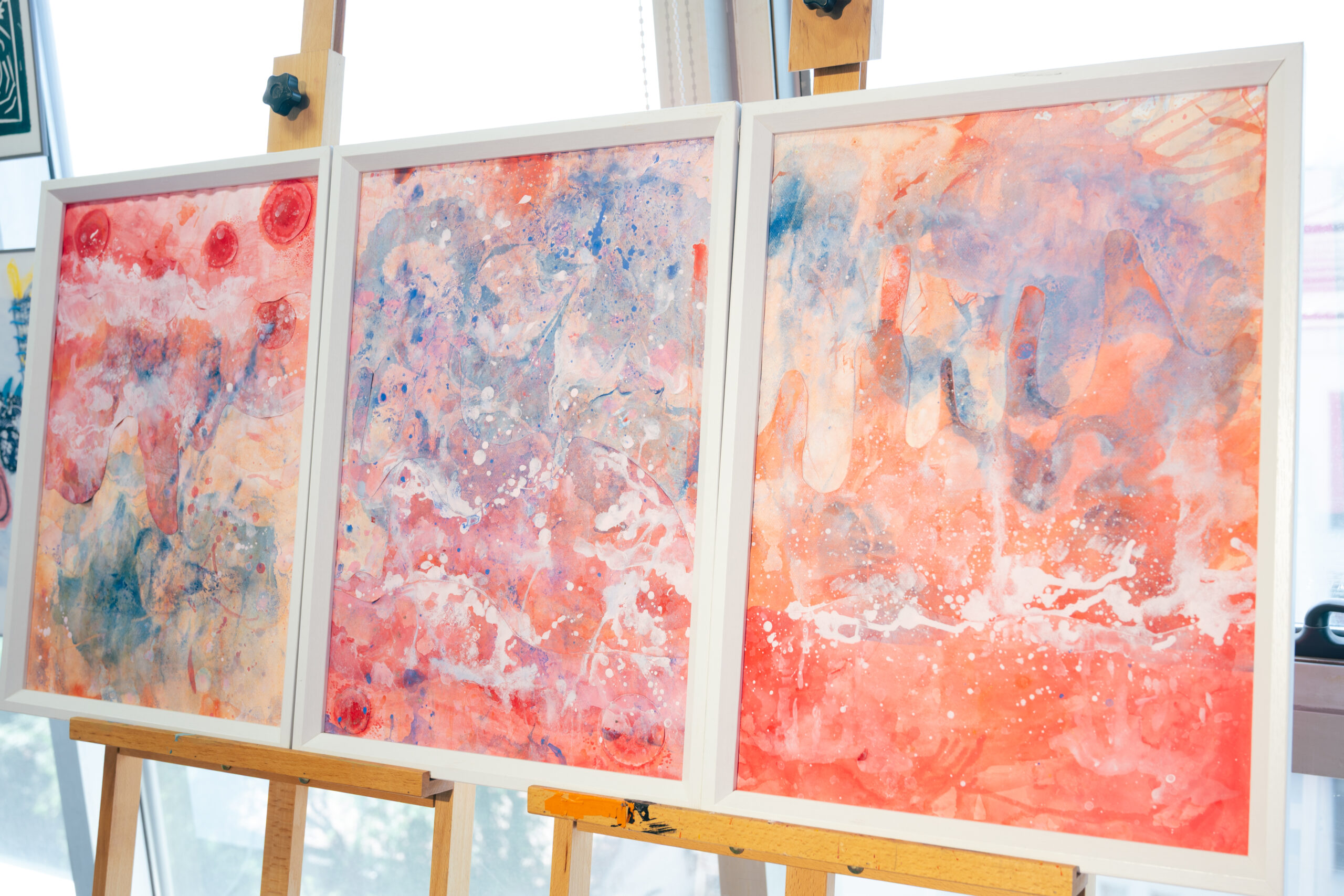 三幅装裱好的抽象水彩画并排展示